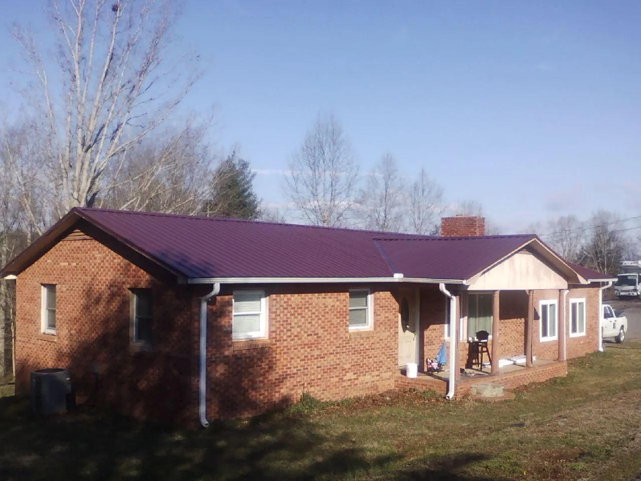 Burgundy metal roof on a brick ranch home with a new addition in Belding